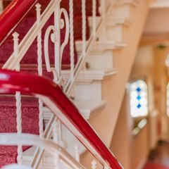 Treppenhaus der Strandvilla Residenz mit rotem Gelaender