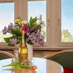 Willkommen im VINETA - Vineta Sektflasche mit Blumenstrauss und Sektglaesern
