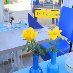 Vineta Strandhotels - Detailaufnahme eines Restauranttisches mit Vase und gelben Rosen